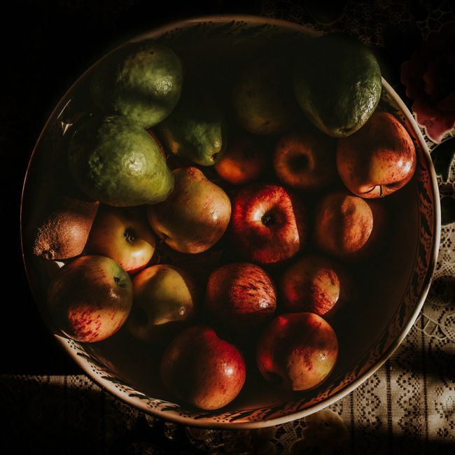 A vibrant display of fresh fruits and vegetables in a sunlit kitchen, showcasing the essence of a raw food diet, with colorful produce like tomatoes, cucumbers, and leafy greens, evoking a sense of freshness and health, with a warm, inviting atmosphere.