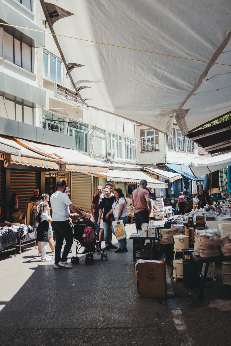 A vibrant market scene with people using reusable bags and containers, colorful fruits and vegetables on display, warm sunlight filtering through, capturing the essence of sustainable living