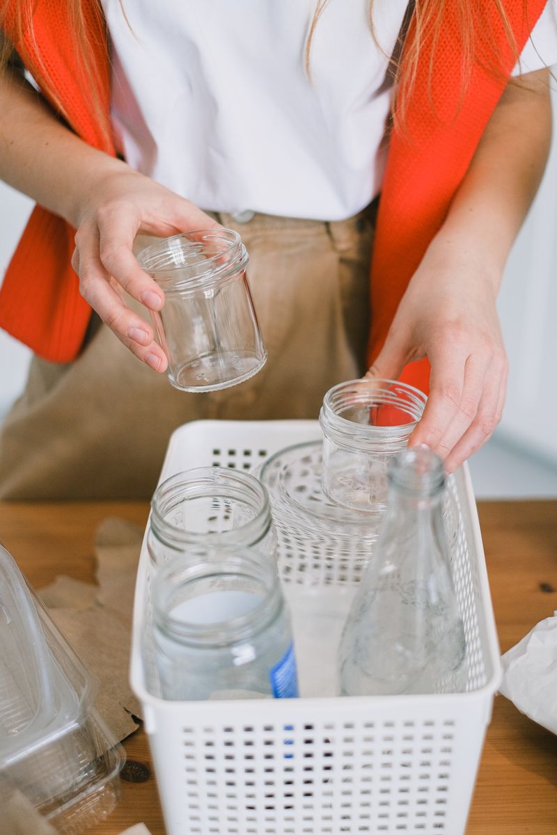 A cozy kitchen filled with repurposed glass jars and a compost bin, sunlight streaming in, creating a warm, inviting space that embodies creativity and sustainability.